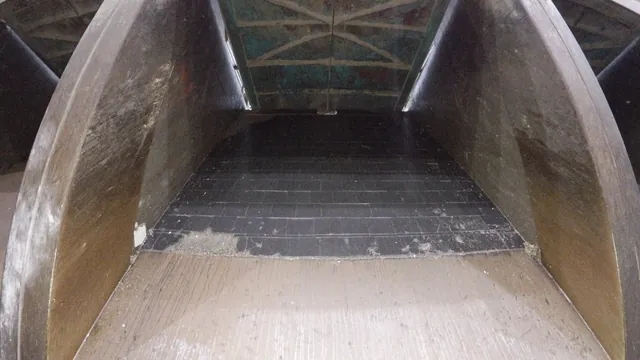 Tippschakt i en avfallsbunker inifrån med sliten stålbeklädnad