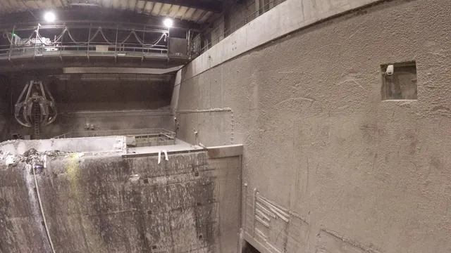 Bunkervägg och trattvägg i en avfallsbunker, i bakgrunden gripskopa och kranbana