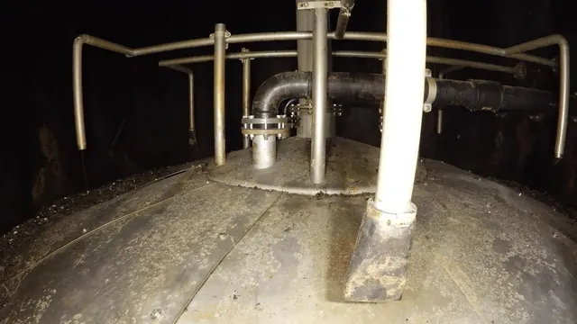 Botten i en ståltank med rörledningar, drönarbild inifrån