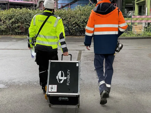 Två medarbetare drar ELIOS-transportväskan till uppdragsplatsen